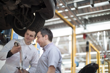Technician showing control arm to customer