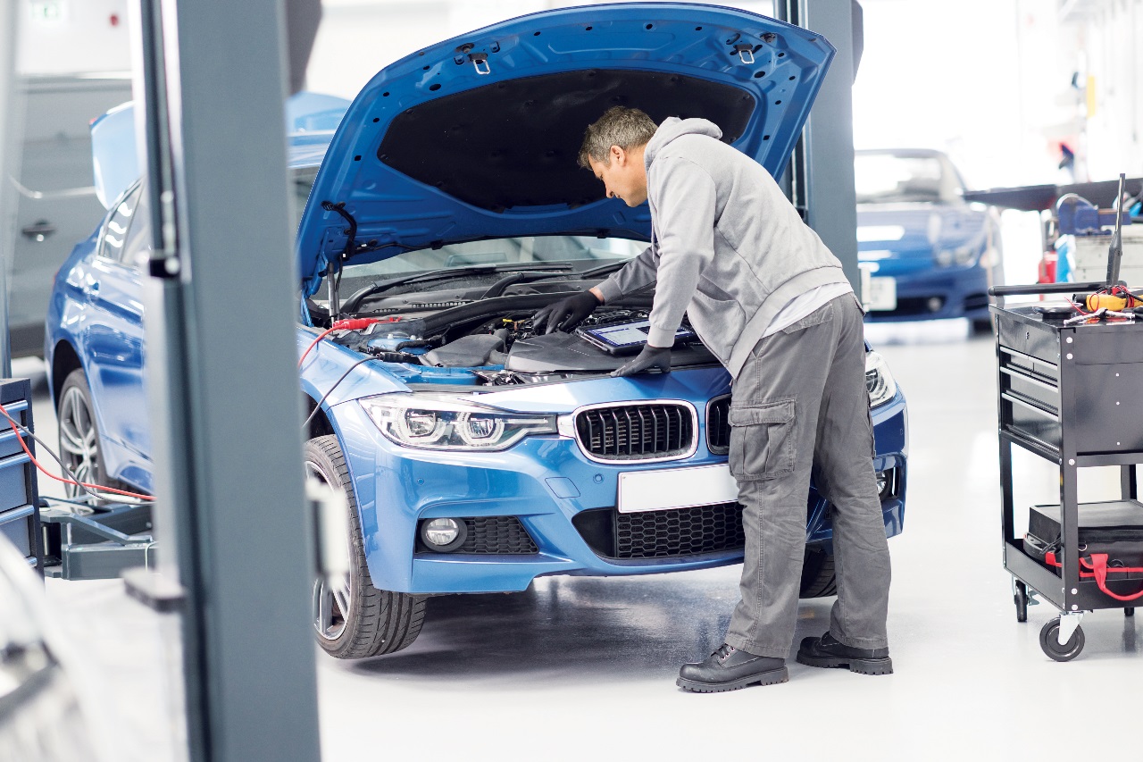 mechanik pracujący przy samochodzie z otwartą maską