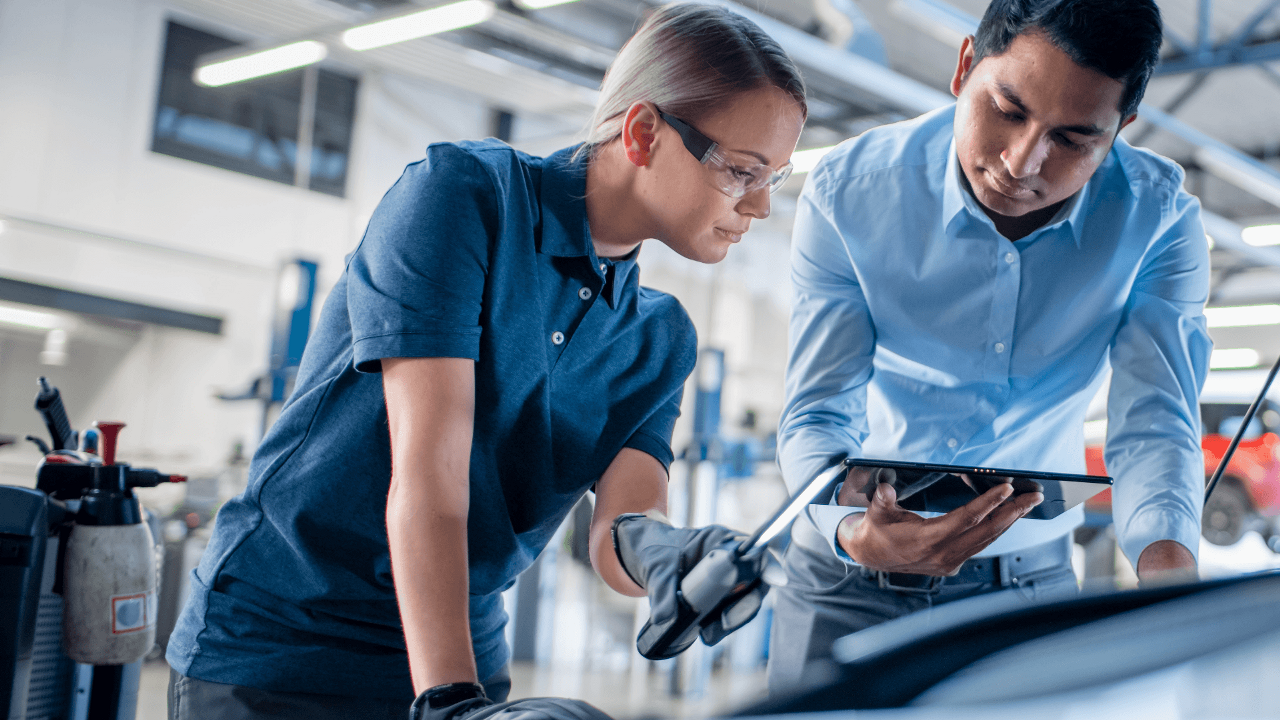 Delphi Technologies Experts using a tablet and an inspection lamp to investigate under the bonnet of a car.
