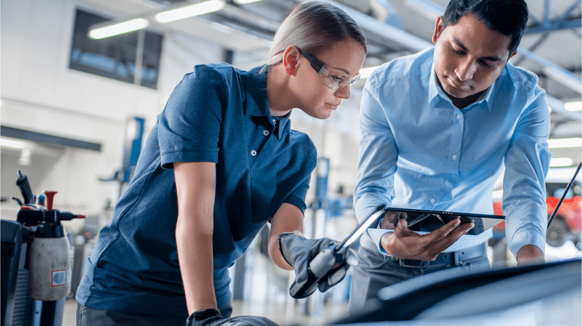 Delphi Experts using a tablet and an inspection lamp to investigate under the bonnet of a car.