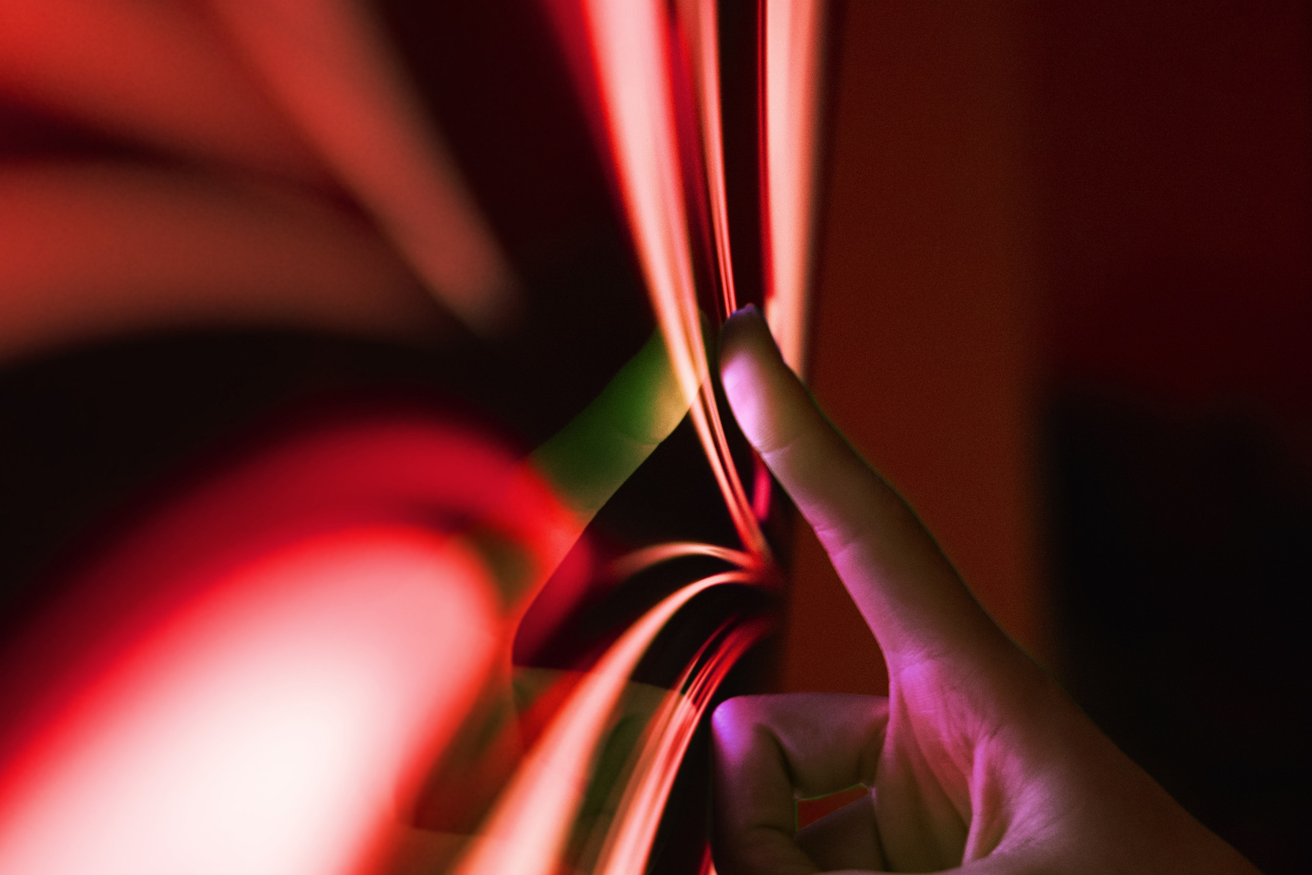 A hand touching PHINIA's red arrow logo