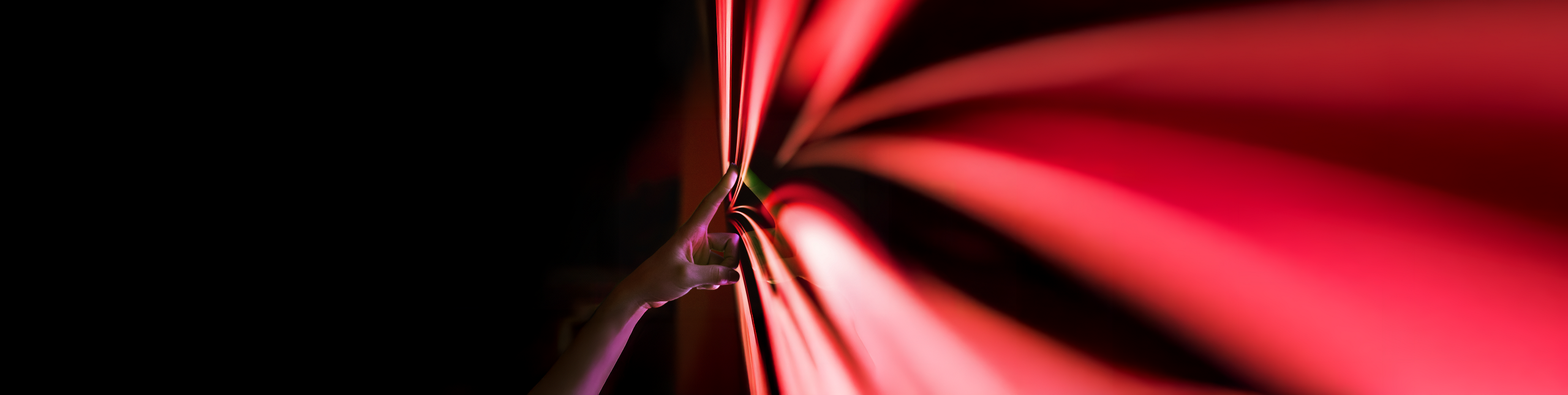 A hand touching PHINIA's red arrow logo