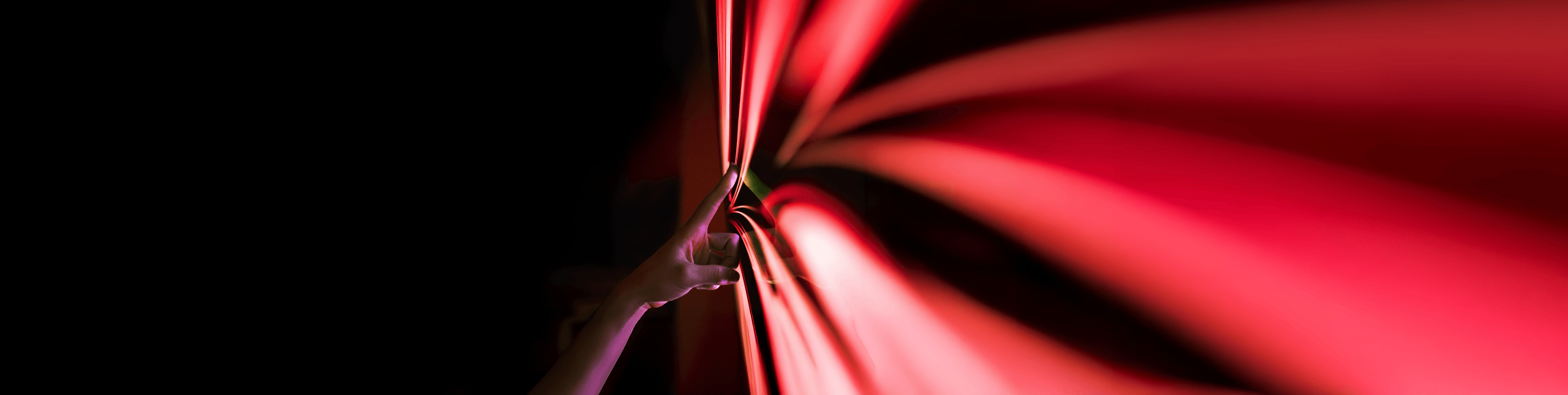 A hand touching PHINIA's red arrow logo