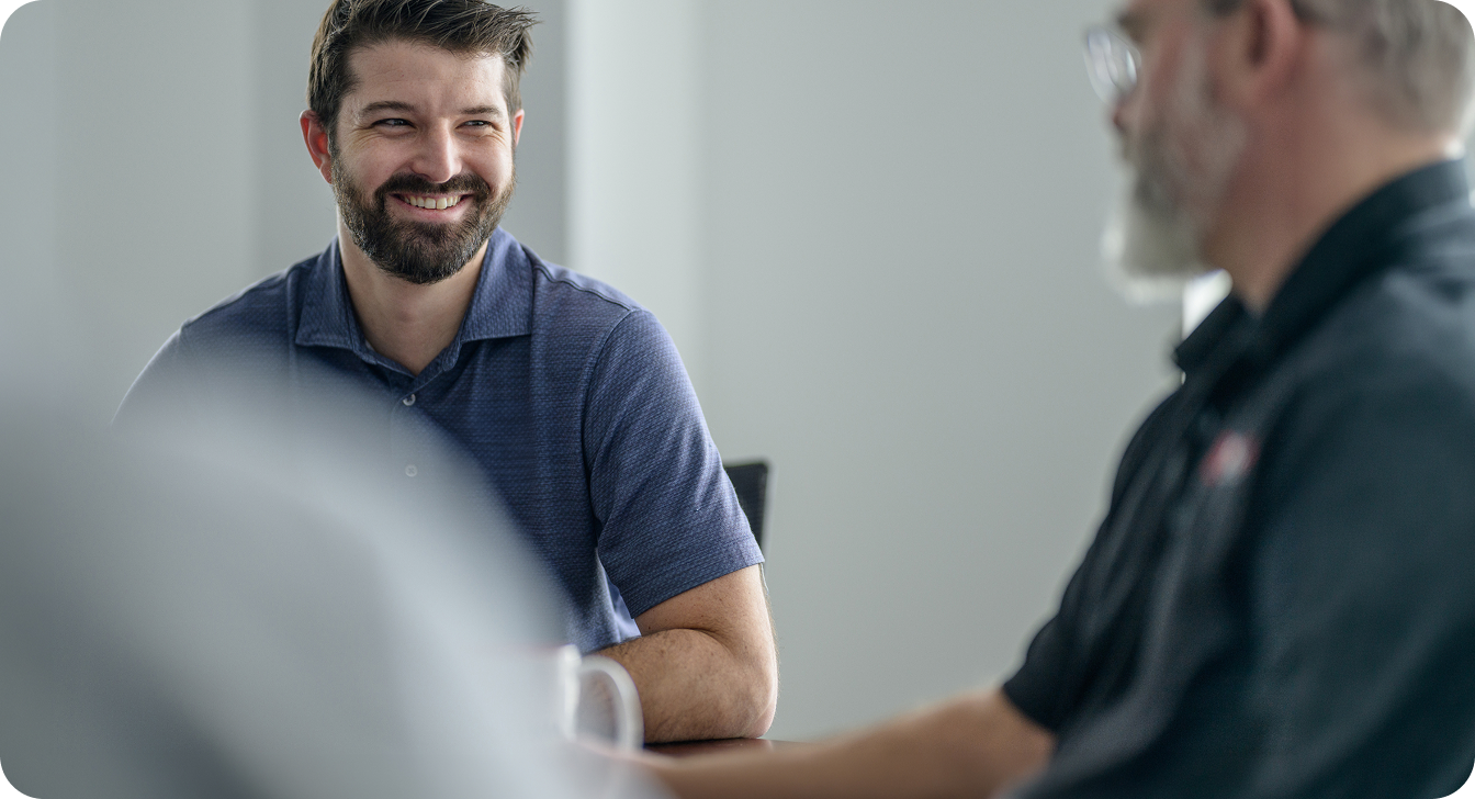 Two colleagues engaged in conversation during a business meeting.