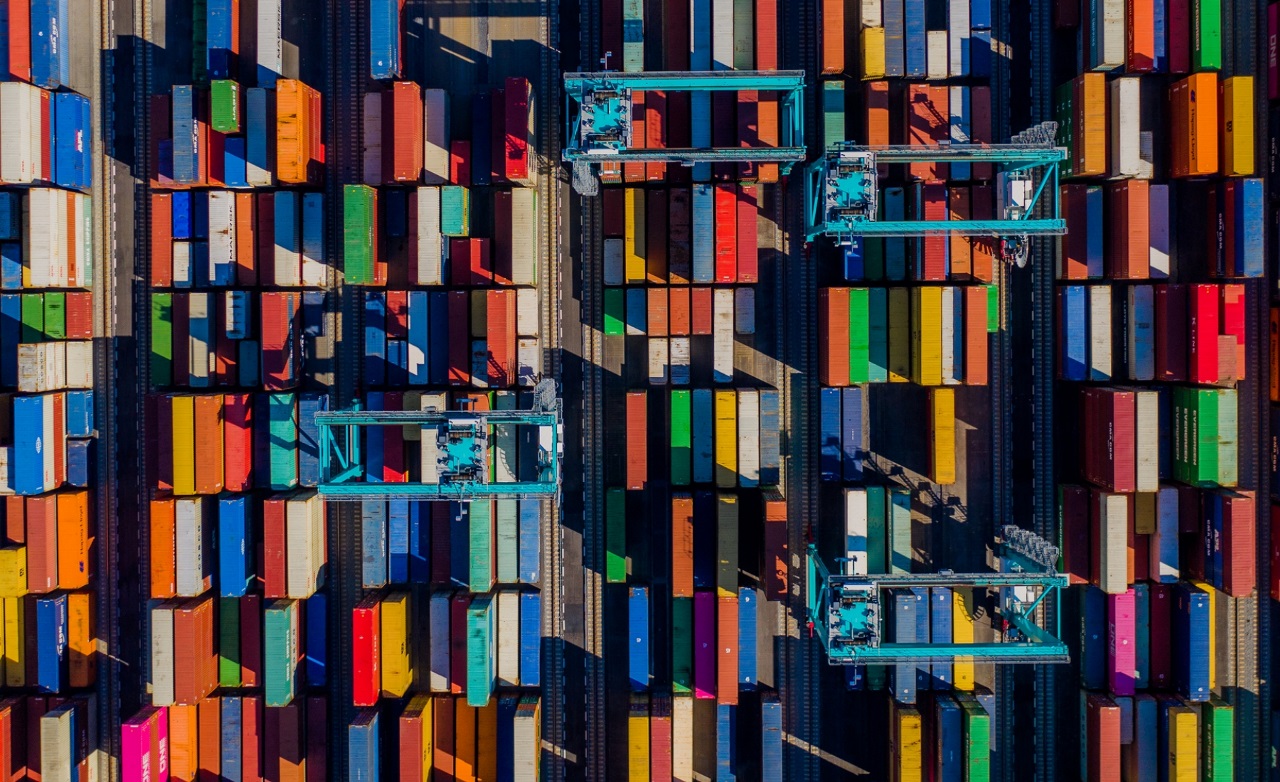 Aerial top-down view of colorful shipping containers organized at a container terminal, showcasing global logistics and freight transportation